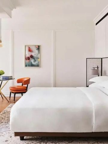 Helles Doppelzimmer mit minimalistischer Einrichtung und stilvollem Kunstwerk