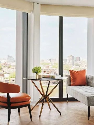 Helle Lounge mit Panoramafenstern und moderner Einrichtung mit Stadtblick