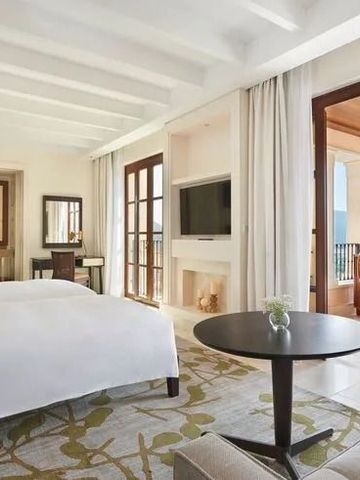Lichtdurchflutetes Hotelzimmer mit großem Bett, Balkon und Bergblick