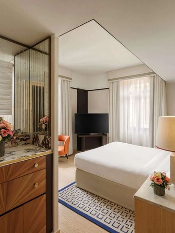 Elegantes Hotelzimmer mit moderner Einrichtung und Blumenarrangement.