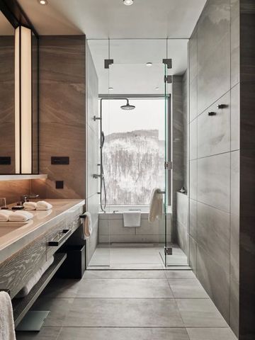 Elegantes Badezimmer mit Dusche und Blick auf schneebedeckte Berge
