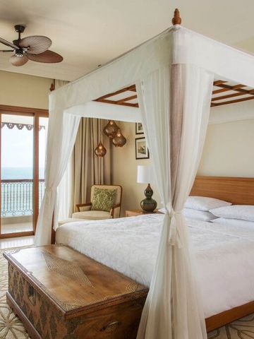 Raum mit Himmelbett und Sicht auf das Meer vom Balkon