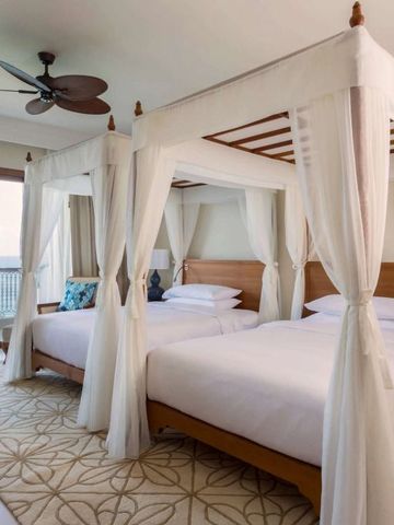 Elegantes Zimmer mit zwei Himmelbetten und Meerblick vom Balkon