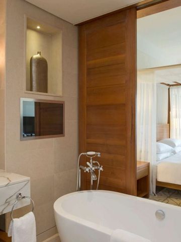 Badezimmer mit Mosaikfliesen und Blick auf ein stilvolles Schlafzimmer