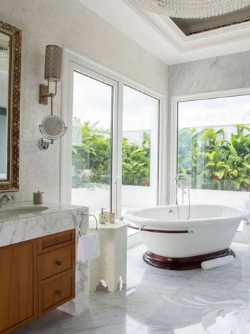 Luxuriöses Badezimmer mit freistehender Badewanne und Gartenblick