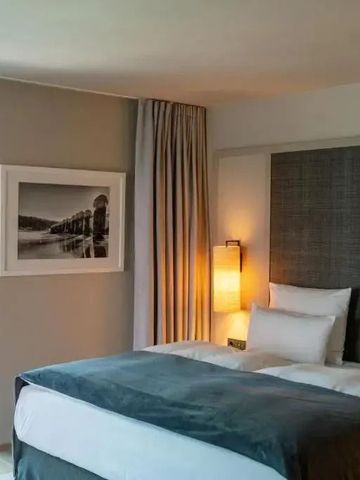 Geschmackvolles Hotelzimmer mit stilvollem Doppelbett und dezenter Beleuchtung.
