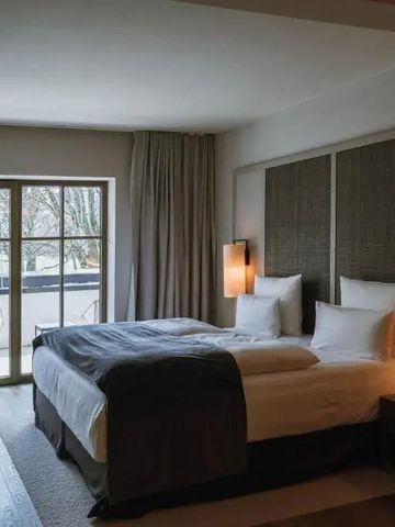 Elegantes Hotelzimmer mit Balkon und großer Fensterfront