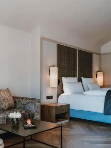 Modernes Hotelzimmer mit Sitzecke und stilvollen Lampen