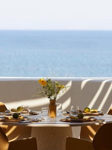 Strahlend gedeckter Tisch auf einer Terrasse mit Meerblick
