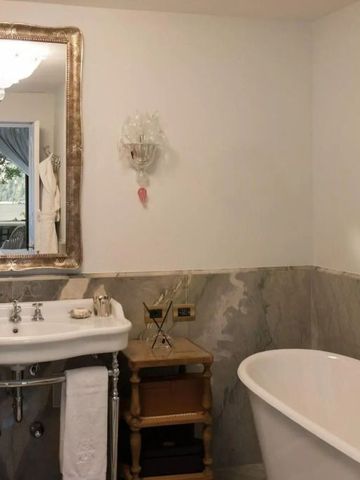 Elegantes Badezimmer mit antikem Spiegel und freistehender Badewanne