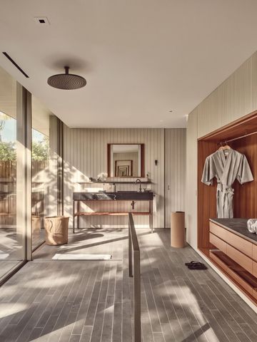 Luxuriöses Badezimmer mit Regenwalddusche und natürlichem Licht.