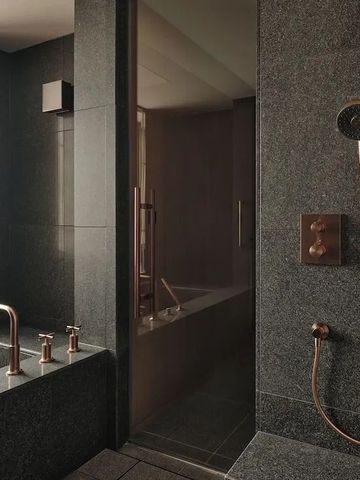 Elegantes Badezimmer mit dunklen Fliesen und modernen Armaturen