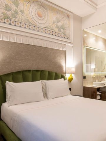 Luxuriös gestaltetes Hotelzimmer mit beleuchtetem Badbereich im Patria Palace Hotel Lecce.