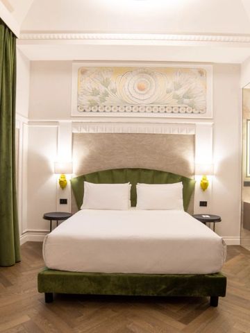 Elegantes Hotelzimmer mit Kingsize-Bett und grünen Akzenten