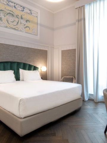 Helles Hotelzimmer mit Doppellbett und künstlerischer Wanddekoration