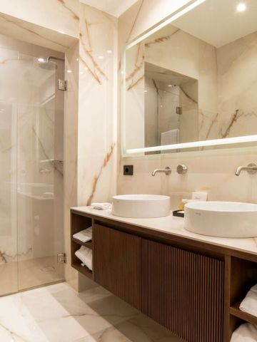 Luxuriöses Badezimmer mit Marmordekor und Doppelwaschbecken