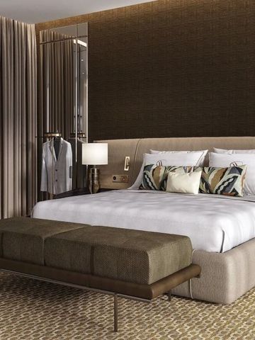 Modernes Schlafzimmer mit stilvollem Dekor und Sitzbank am Fußende des Bettes