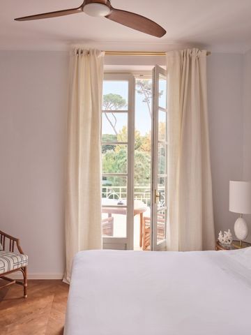 Helles Hotelzimmer mit großem Bett und Balkon mit Gartenblick