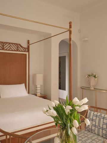 Hotelzimmer mit Doppelbett und frischen Tulpen auf dem Tisch
