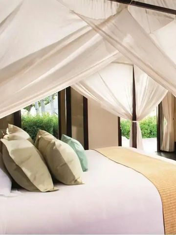 Hotelzimmer mit Himmelbett und hellen, luftigen Vorhängen