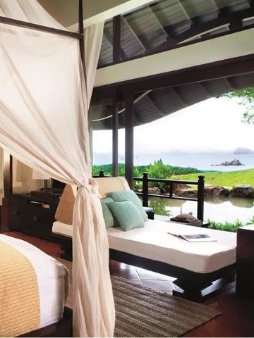 Geräumiges Zimmer mit Blick auf einen ruhigen Garten und das Meer