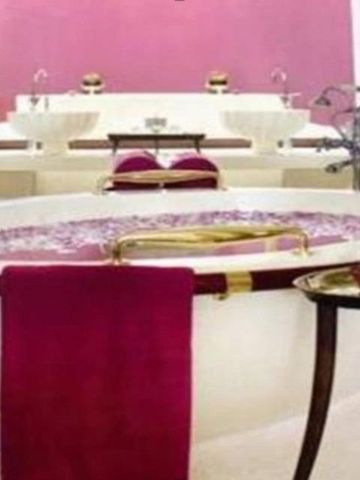 Luxuriöses Badezimmer mit runder Badewanne in Phulay Bay, rosa Akzentwand