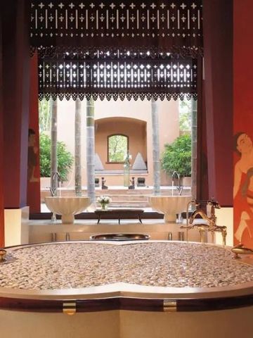Luxuriöses Badezimmer mit Blick in den Garten und kunstvoller Innenraumgestaltung