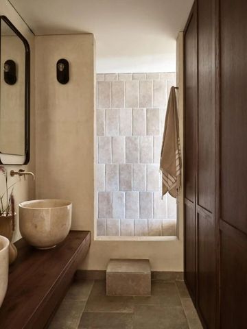 Luxuriöses Badezimmer mit Natursteinelementen und dekorativer Beleuchtung.