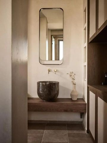 Elegantes Waschbecken mit Kunstdeko und modernem Spiegel.