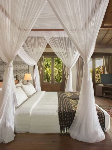 Geräumiges Zimmer mit Baldachinbett und großen Fenstern zur Natur