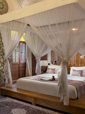Elegantes Schlafzimmer mit Himmelbett und Holzwänden im Boutique-Stil