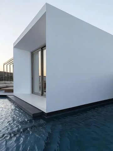 Moderne kubische Architektur über einem Pool bei Sonnenuntergang