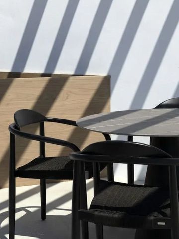 Moderne Terrasse mit stilvollen schwarzen Stühlen im Sonnenlicht