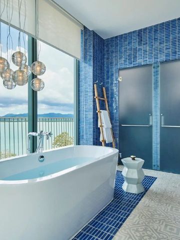 Luxuriöses Badezimmer mit freistehender Badewanne und Meerblick