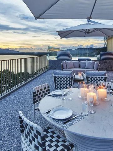 Terrasse mit Esstisch und Meerblick bei Sonnenuntergang