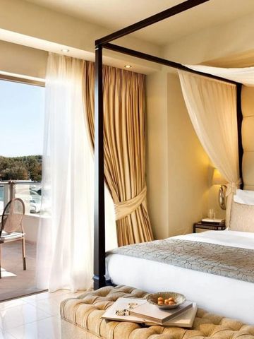 Luxuriöses Himmelbett in einem Zimmer mit Balkon und Aussicht.