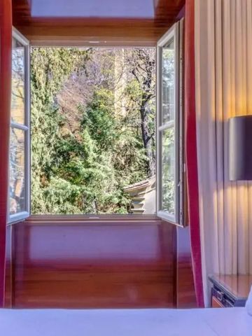 Helles Zimmer mit offenem Fenster und Blick auf grüne Bäume