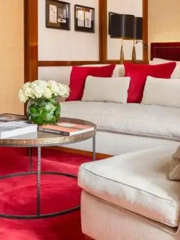 Elegant dekoriertes Wohnzimmer mit rotem Teppich und komfortablem Sofa