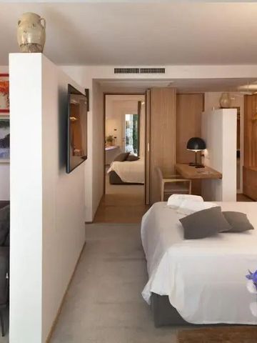 Geräumiges Hotelzimmer mit moderner Einrichtung und Kunstwerken an den Wänden
