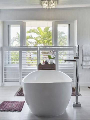 Modernes Badezimmer mit freistehender Badewanne und Gartenblick