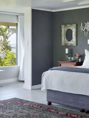 Elegantes Schlafzimmer mit grauen Wänden und Gartenblick