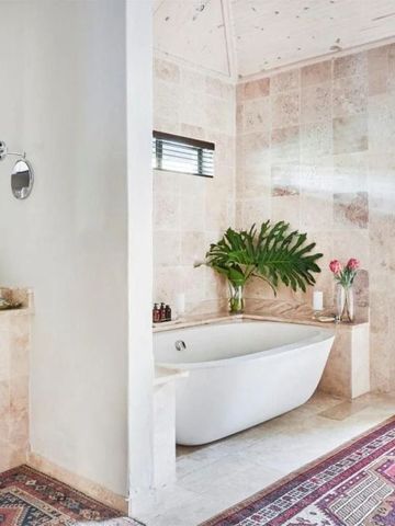 Luxuriöses Badezimmer mit freistehender Badewanne und Pflanzen