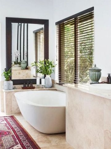Modernes Badezimmer mit freistehender Badewanne und großen Fenstern
