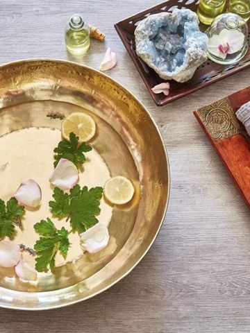 Luxuriöse Spa-Schale mit Blütenblättern Zitronenscheiben und Ölen
