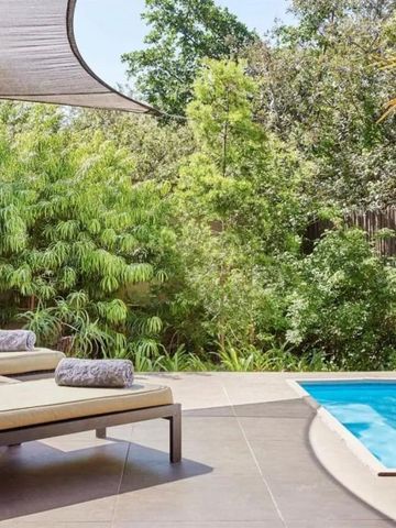 Sonnenliegen am Pool mit üppigem Garten im Hintergrund