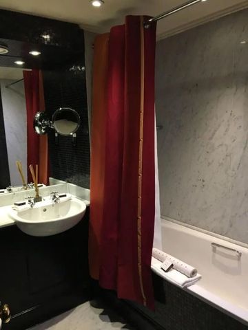 Elegantes Badezimmer mit Doppelwaschbecken, Marmorwand und rotem Duschvorhang