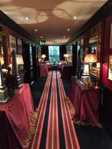 Opulenter Hotelgang mit reicher Dekoration und kunstvollen Spiegeln