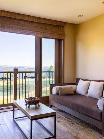 Wohnbereich mit Sofa, Couchtisch und Balkonblick auf die Landschaft