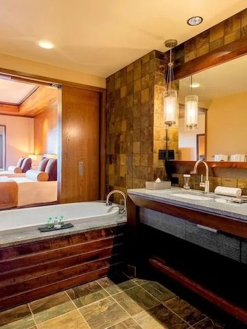 Offenes Badezimmer mit freistehender Badewanne und Blick ins Schlafzimmer