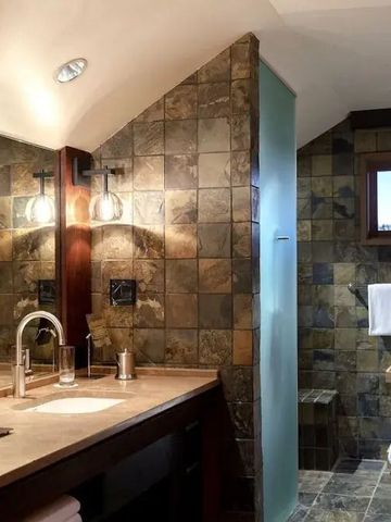 Luxuriöses Badezimmer mit Marmorfliesen und modernen Armaturen